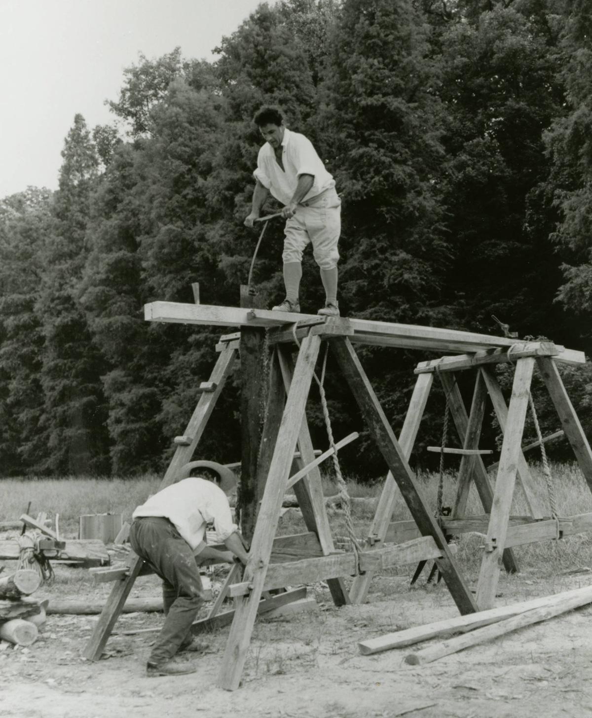 Pit sawing a framing member using colonial tools and techniques for reconstruction of the 16-sided treading barn in 1996.