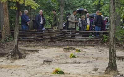 Visitors look on at a row of grave shafts uncovered during the Slave Cemetery Survey.